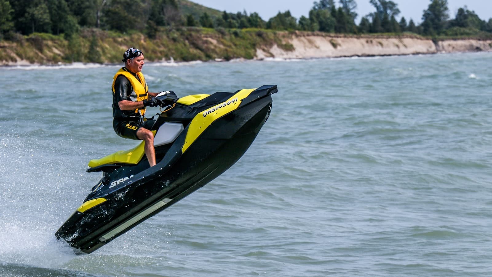 A guest learning to ride a jet ski with an instructor alongside
