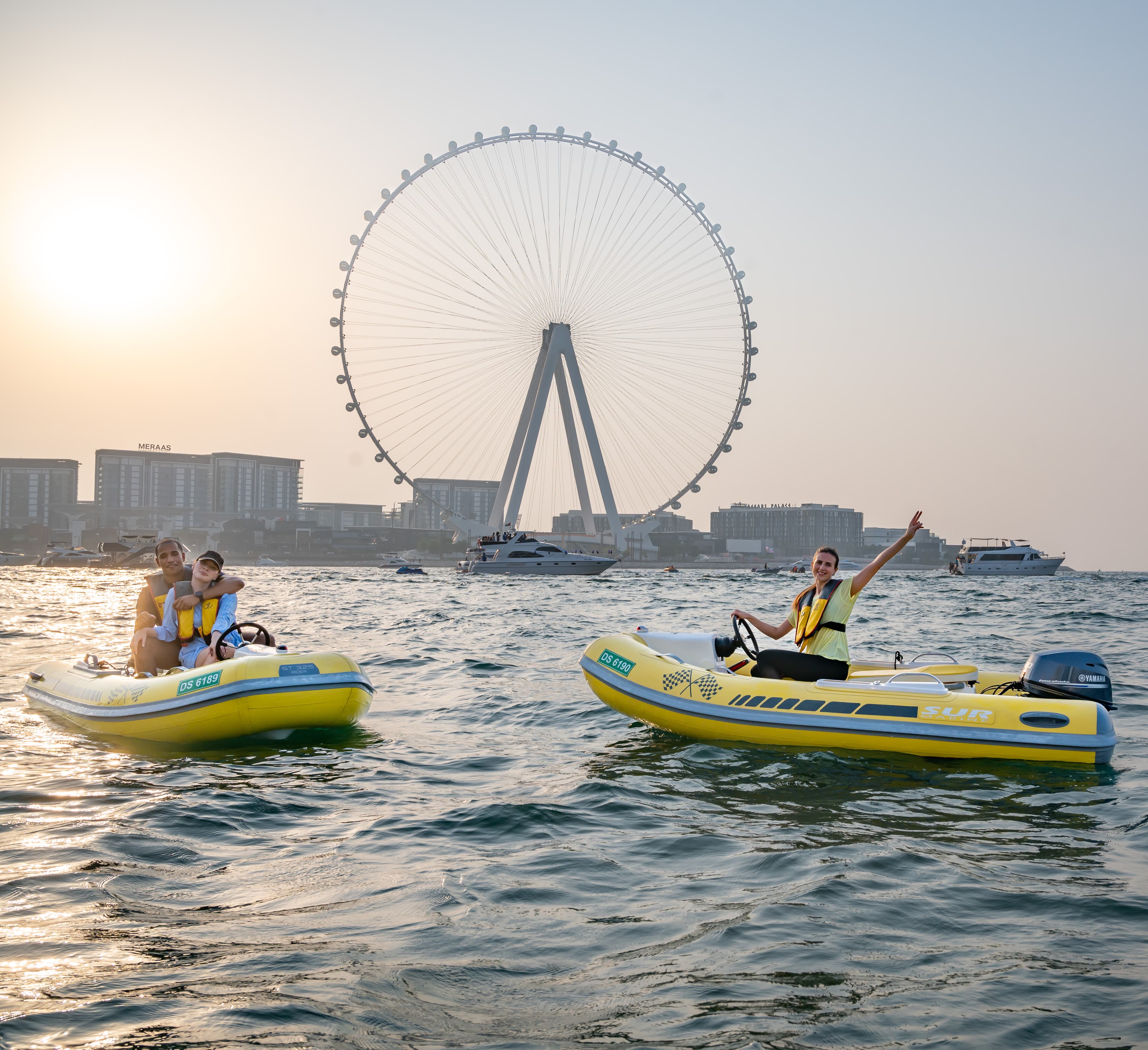 Yellow Costa Viva self-drive speedboats in front of the Ain Dubai observation wheel